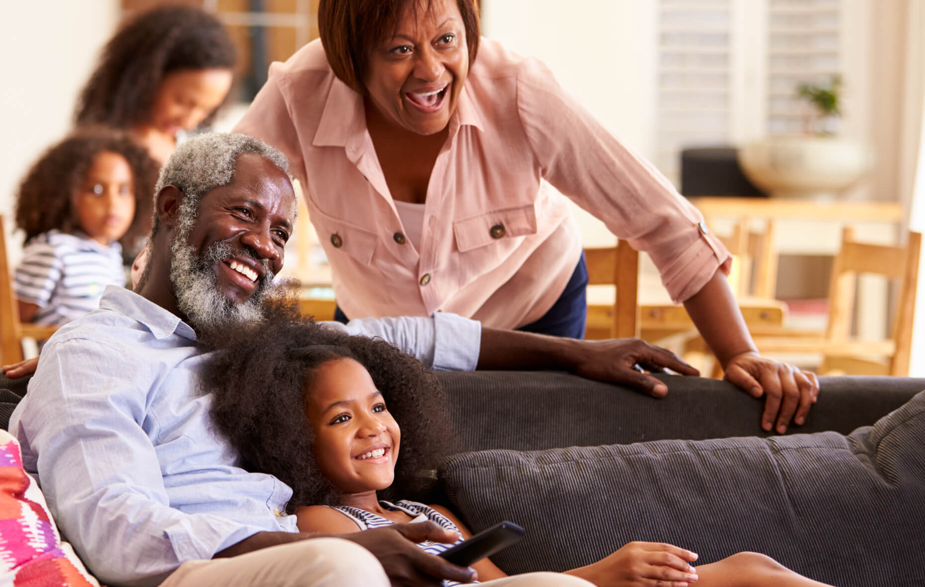 Grandparents enjoying watching a movie with their granddaughter.